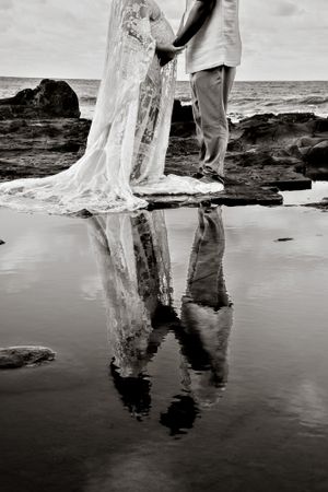 Black and white beach photography capturing reflections in wet sand.