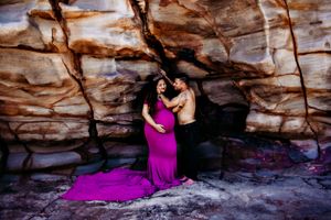 Artistic photo series in sandstone cave with flowing magenta dress.