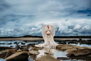 Dramatic coastal photography with rocky shoreline and moody cloudy sky backdrop.