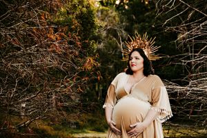 Artistic maternity portrait session captured in natural outdoor setting.