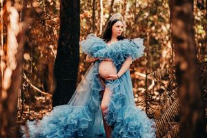 Forest maternity session featuring ethereal blue gown with dramatic movement.
