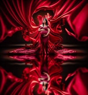 Abstract art with flowing red fabric creating dynamic patterns against a dark background.