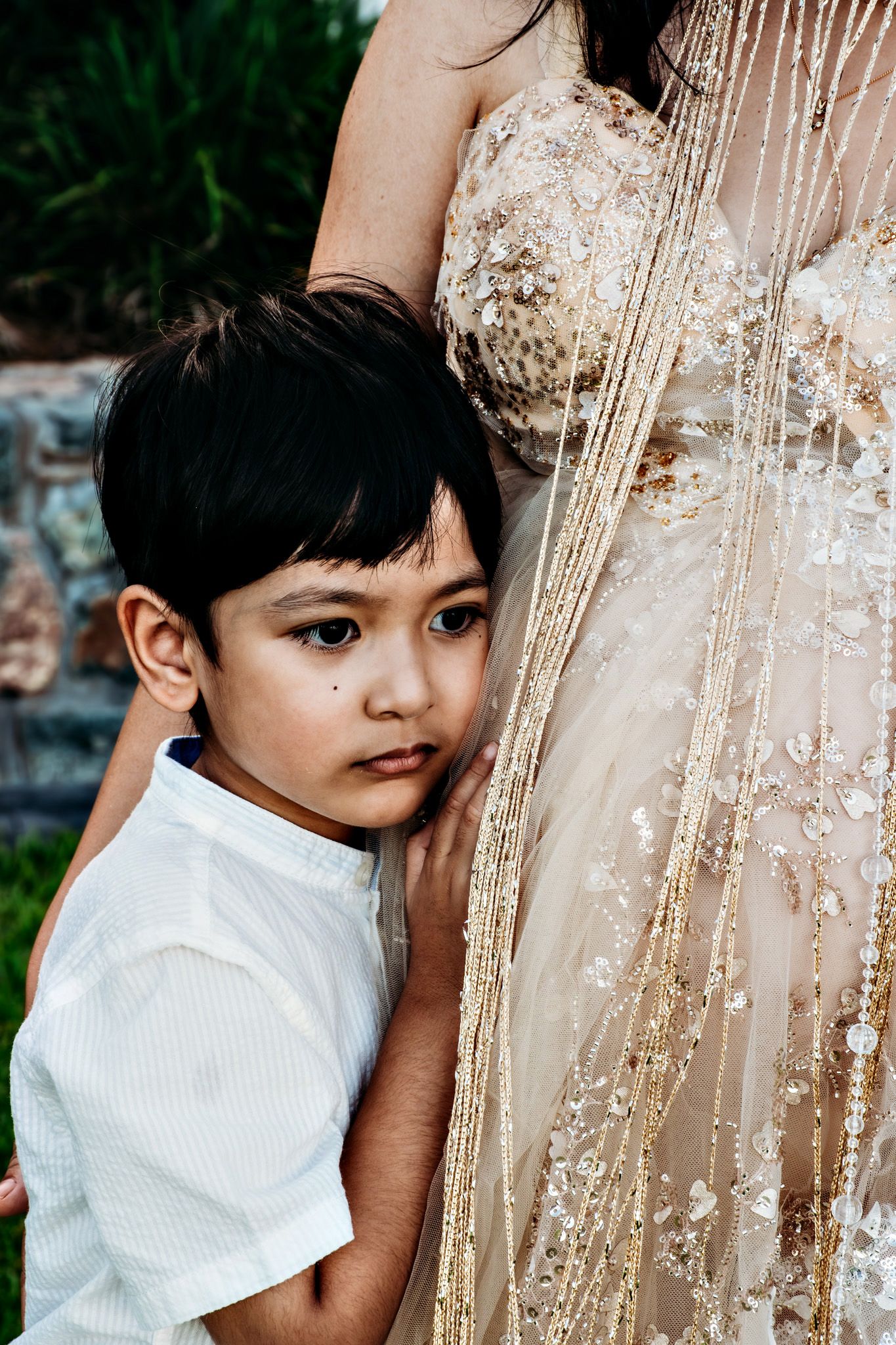 Close-up details of a sequined dress with a child in white.
