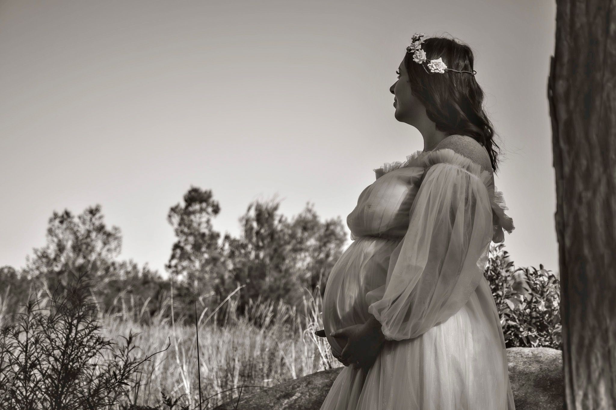 Black and white maternity portraits in natural outdoor setting.