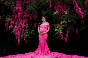 Vibrant pink flowering trees create a dramatic backdrop in a garden setting.