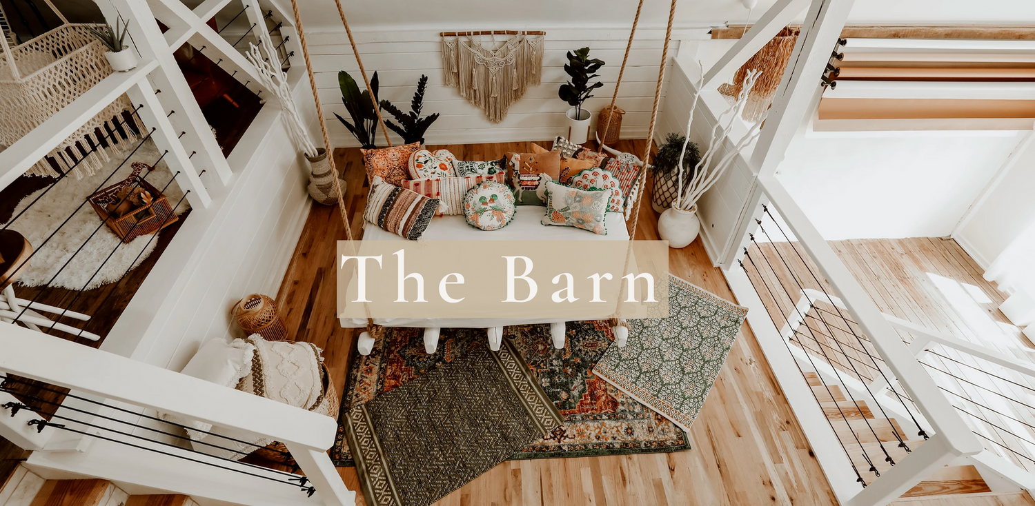 Rustic barn interior with white beams and wooden furniture styled for events.