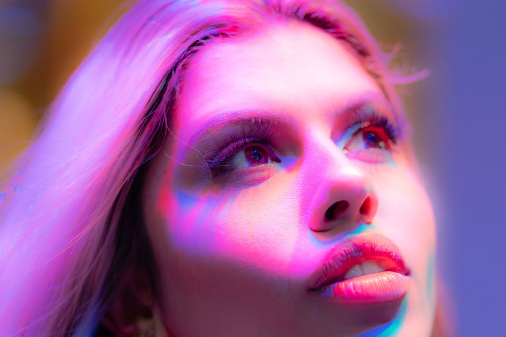 A close up of beautiful Brazilian model, Beatriz Sonnewend's face with different colour lights on her face