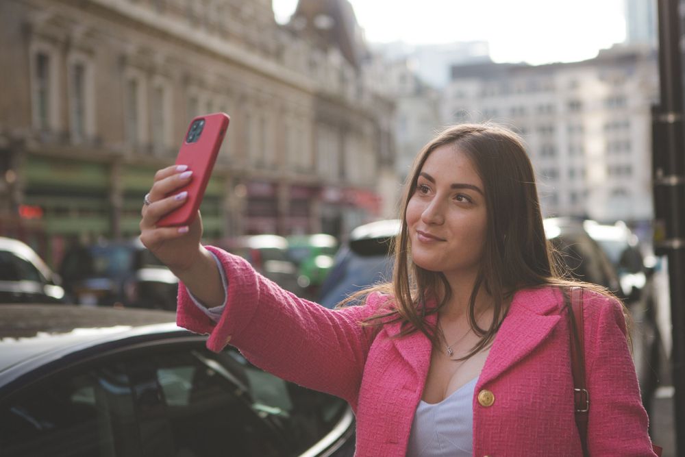 Gorgeous Ukrainian model, Stasis, wearing a pink jacket and taking a selfie in London