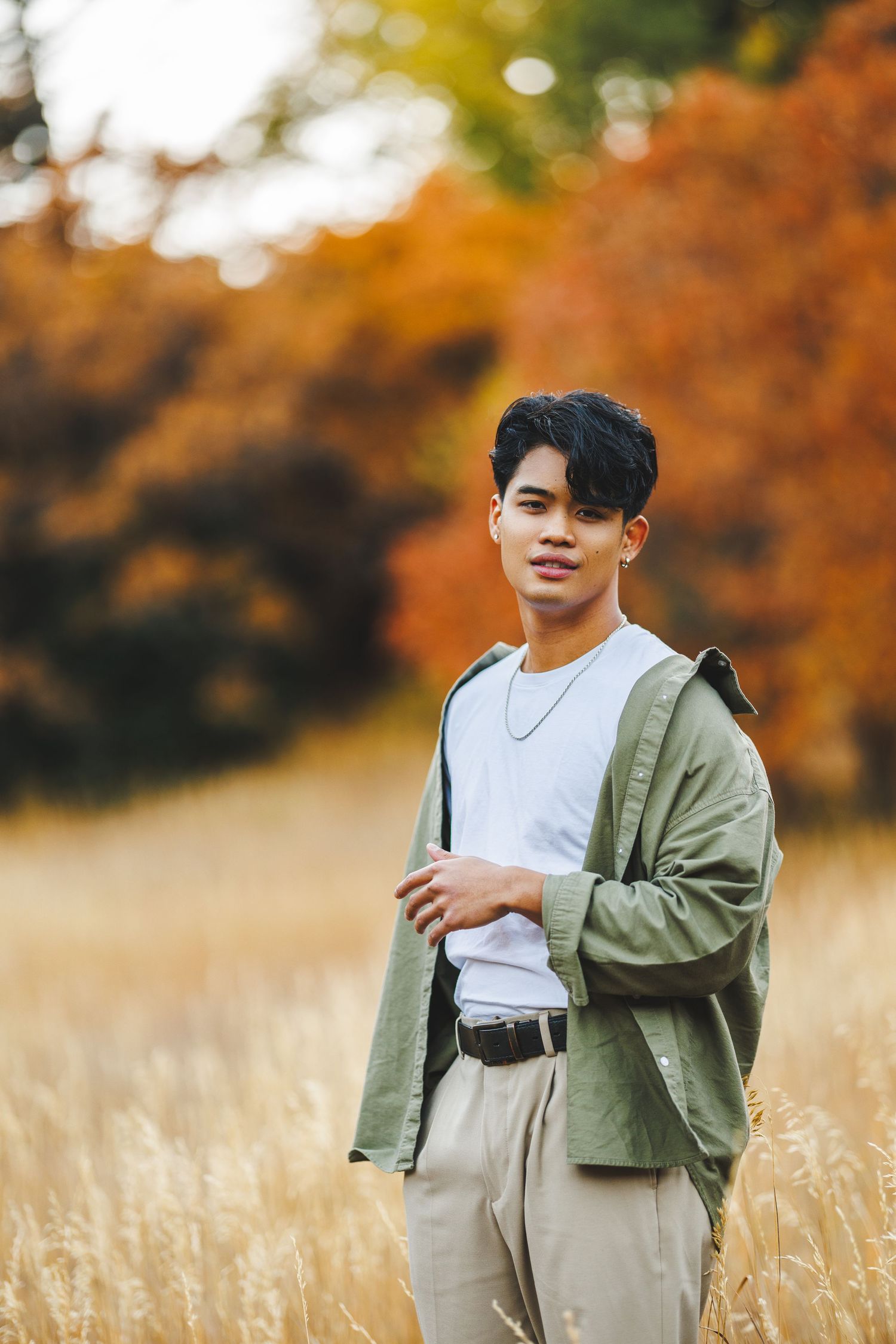 Casual outdoor portrait in olive jacket and white shirt amid autumn wheat field.