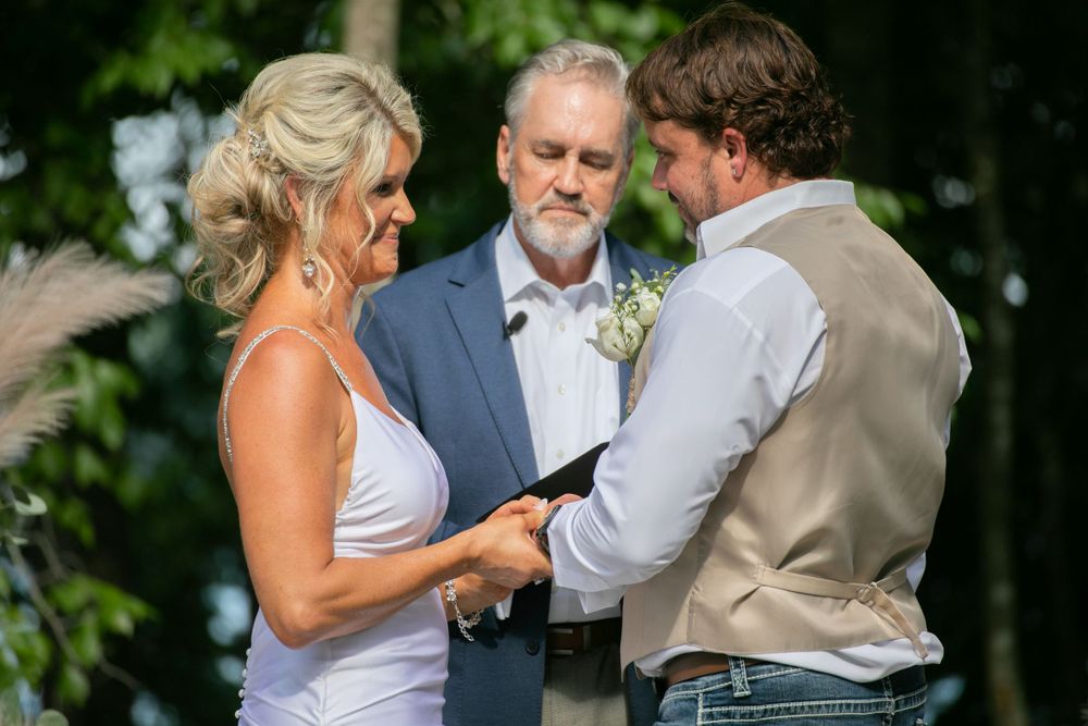 bride and groom exchange rings during their wedding ceremony at Lanier islands in Buford georgia