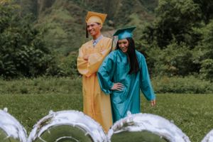 Graduation celebration with flowing white decorations and mountain scenery.