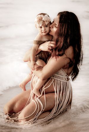 Intimate beach portrait showing affection between parent and child in soft lighting.