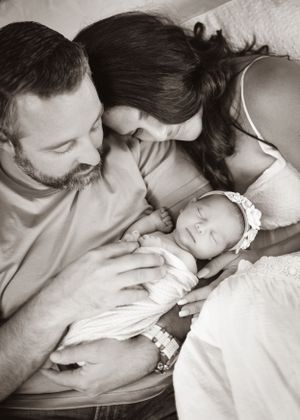 Intimate black and white portrait of family with newborn baby.