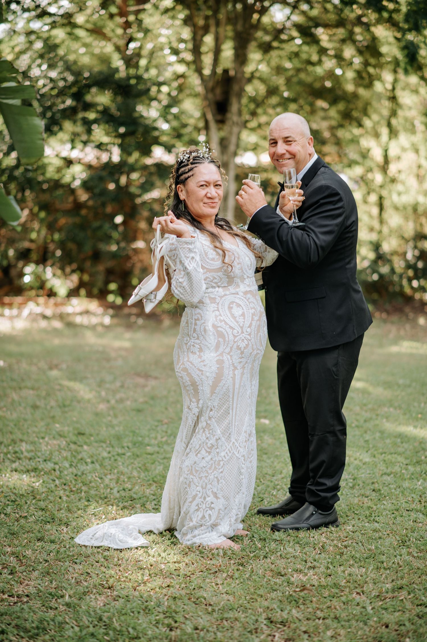 A joyful celebration moment on a grassy lawn during a wedding.