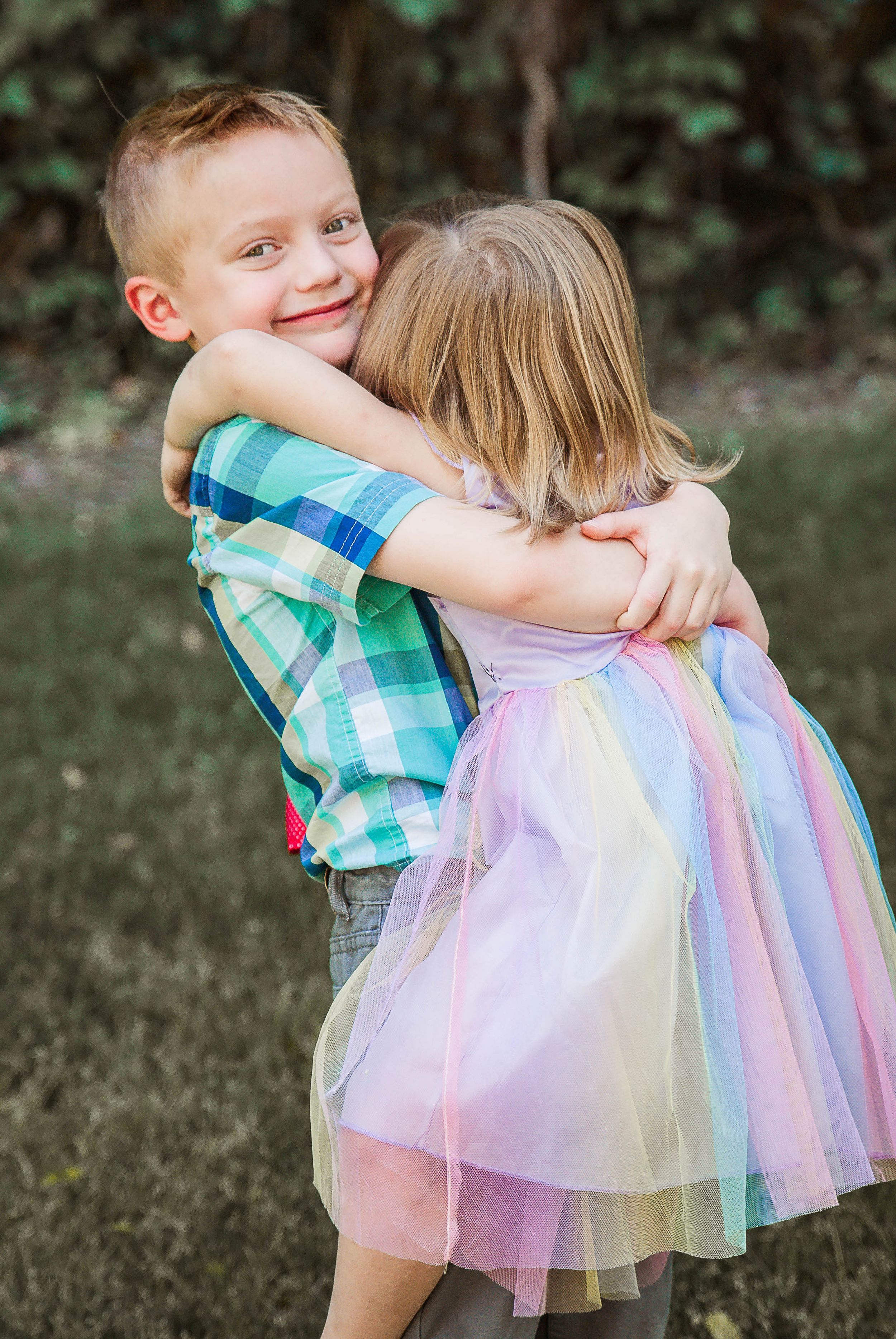 a family photo with two siblings hugging each other