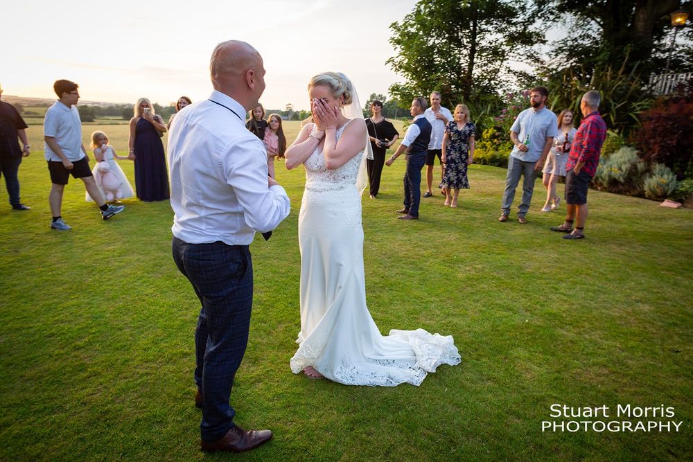 Bride puts her hands over her face in embarrassment before thei first dance in the gardens at west tower Ormskirk