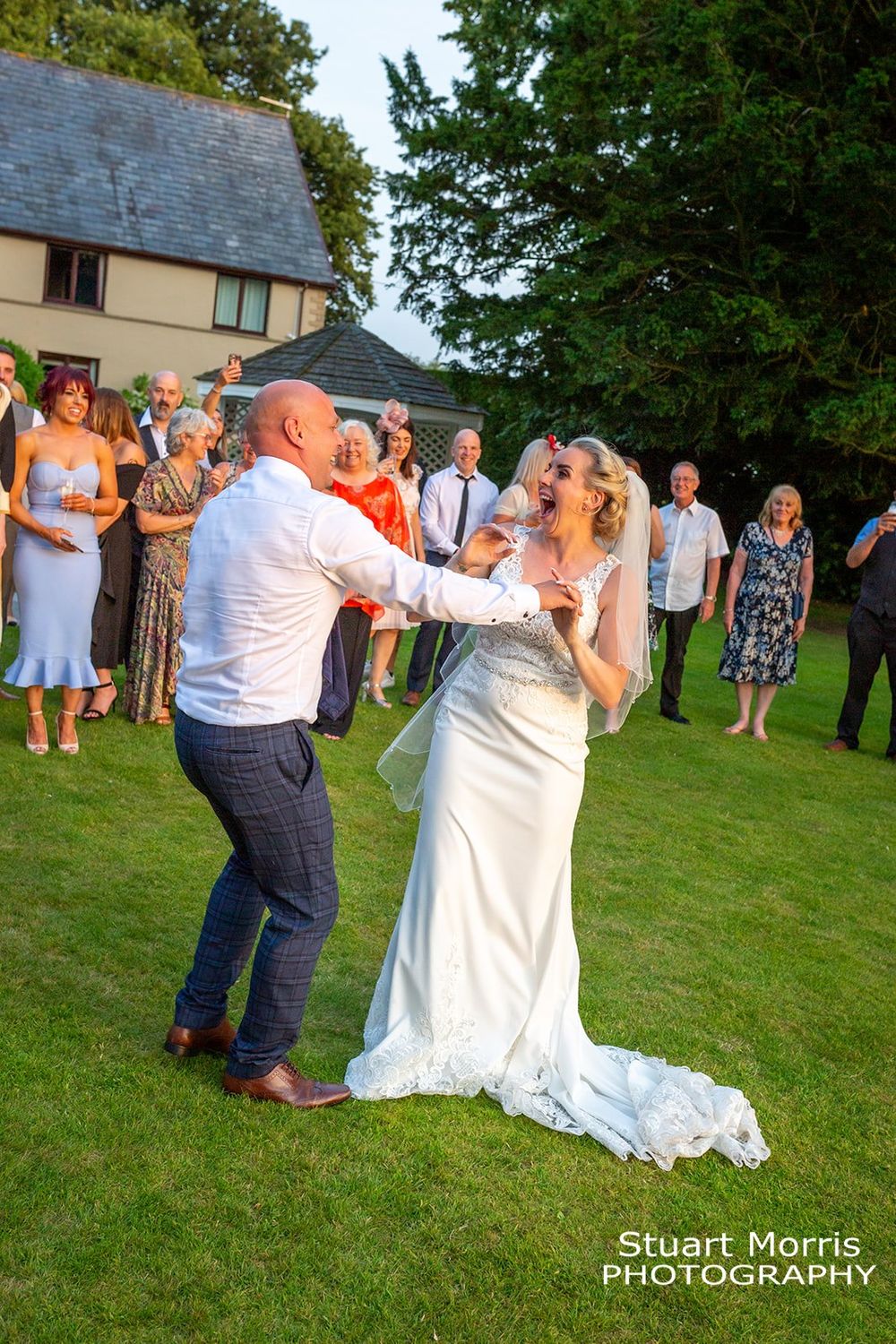 Bride and groom having fun dancing in the sunshine west tower Ormskirk wedding photographer.