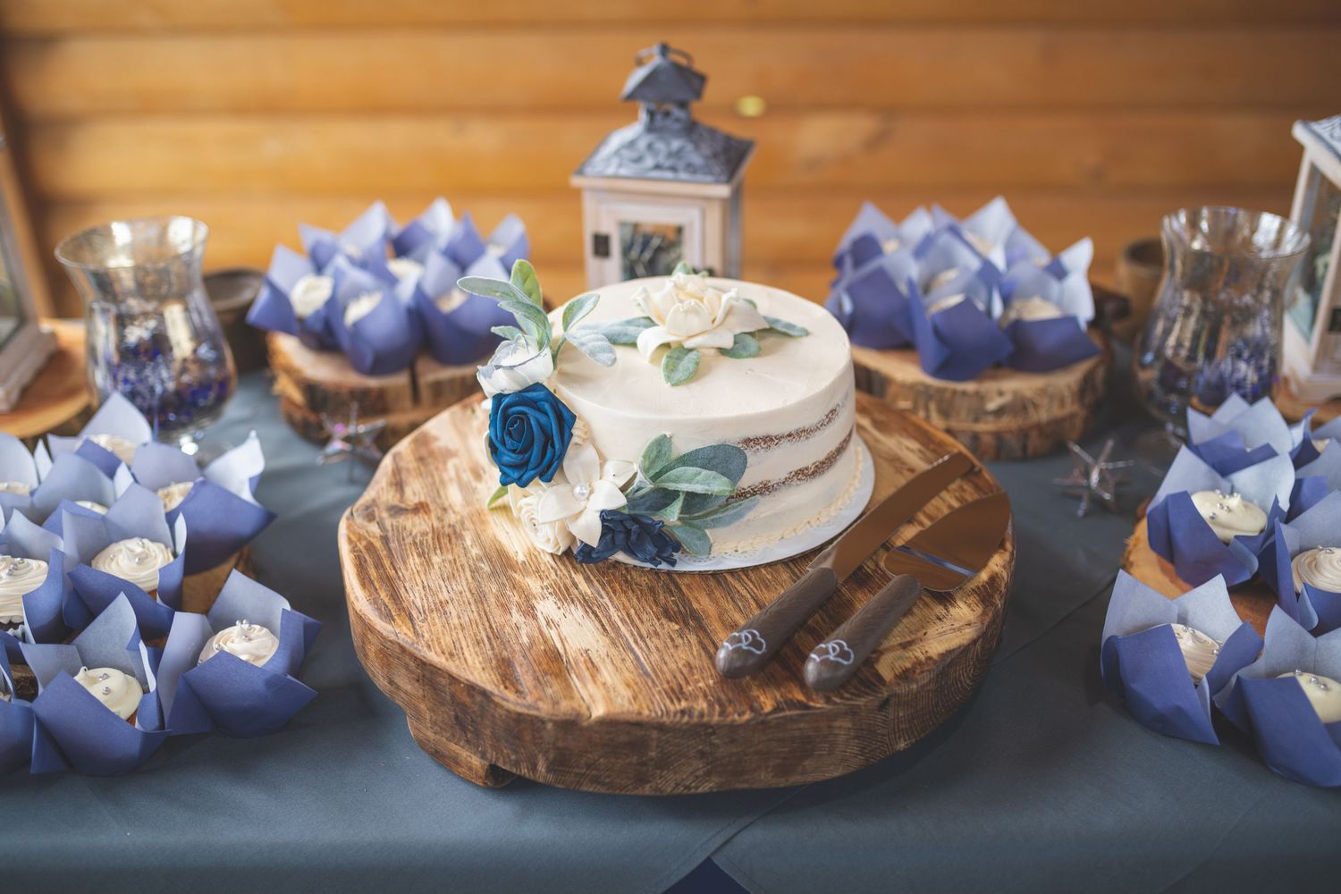 Image of a wedding cake display with cutting utensils and blue decor