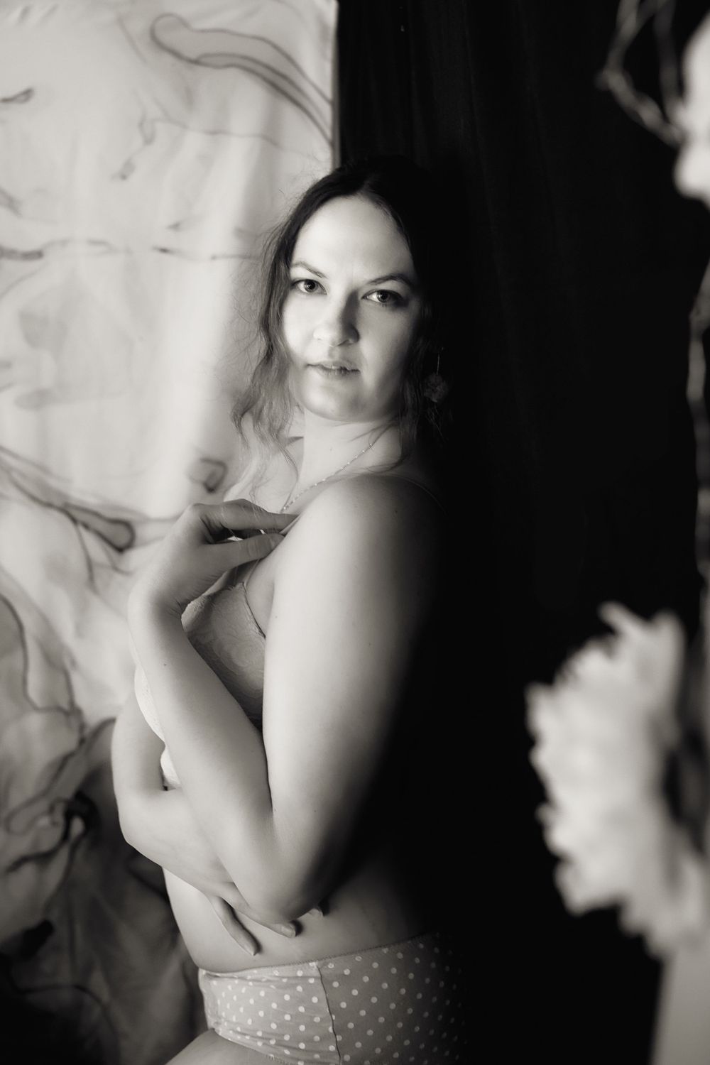 dark haired woman in lingerie posing and looking at camera