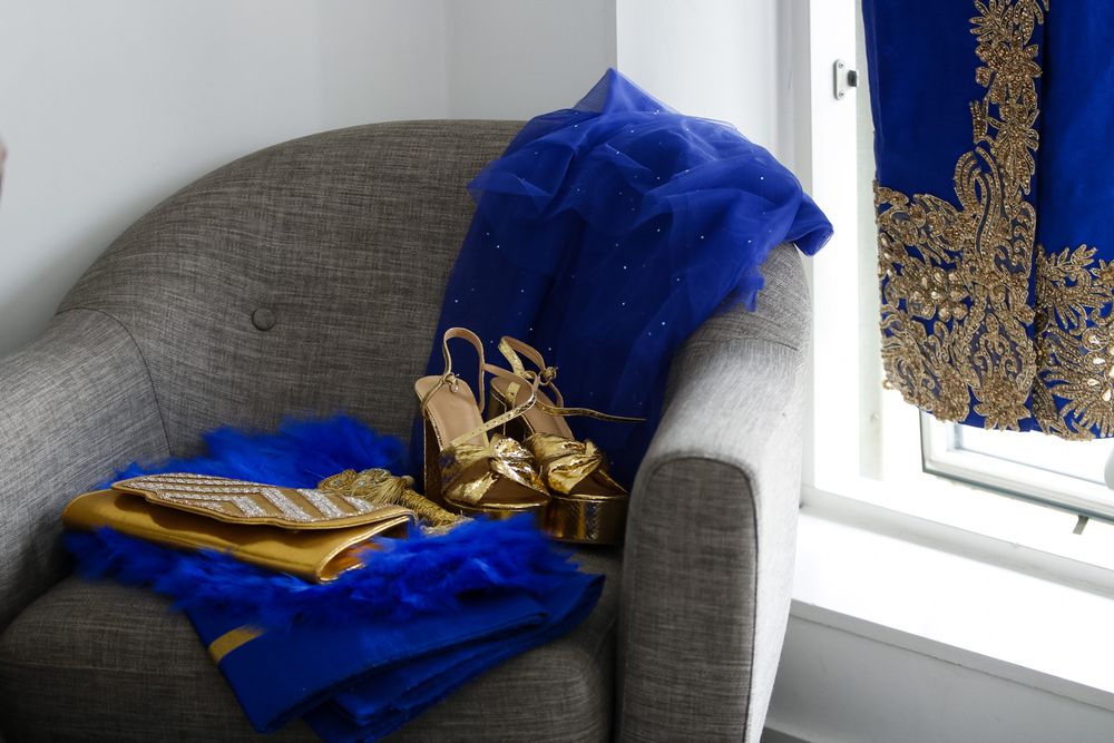 Royal blue traditional garment with gold details arranged near sunny window.
