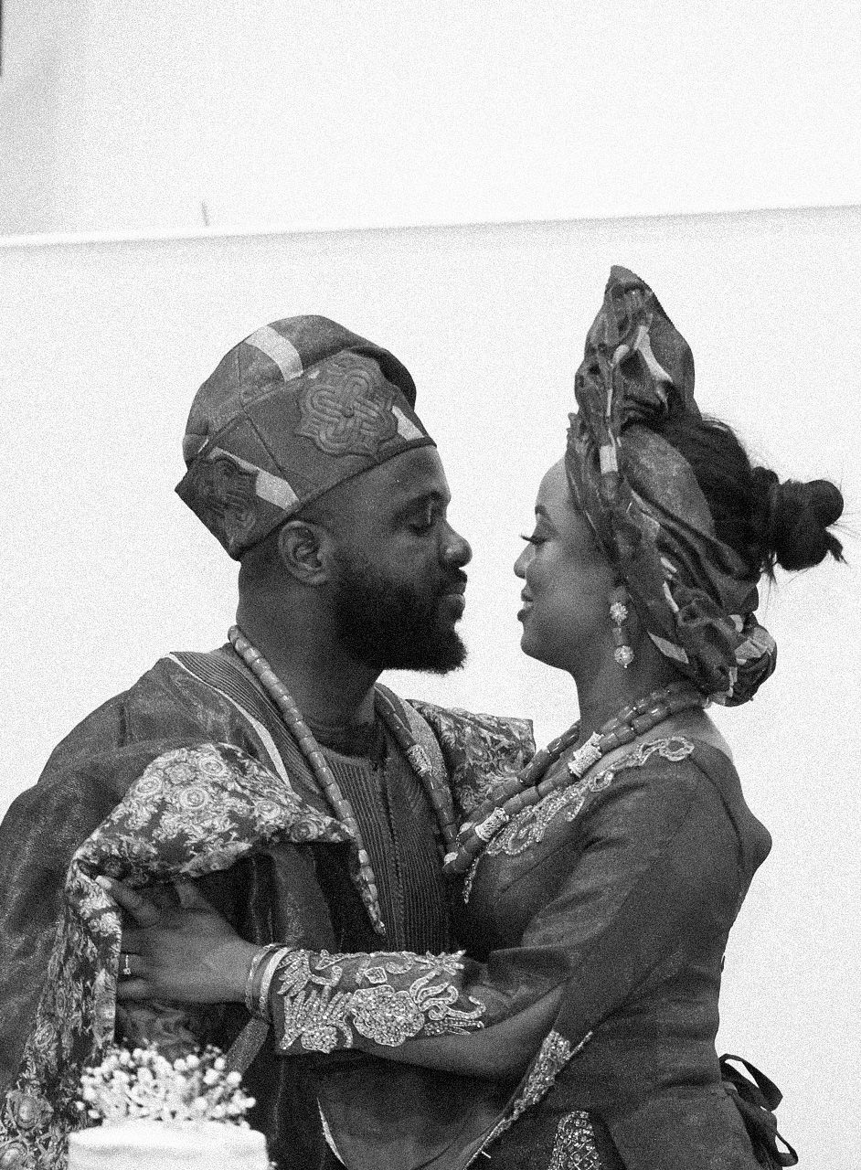 Black and white photo series showing a couple in traditional African dress sharing intimate moments.