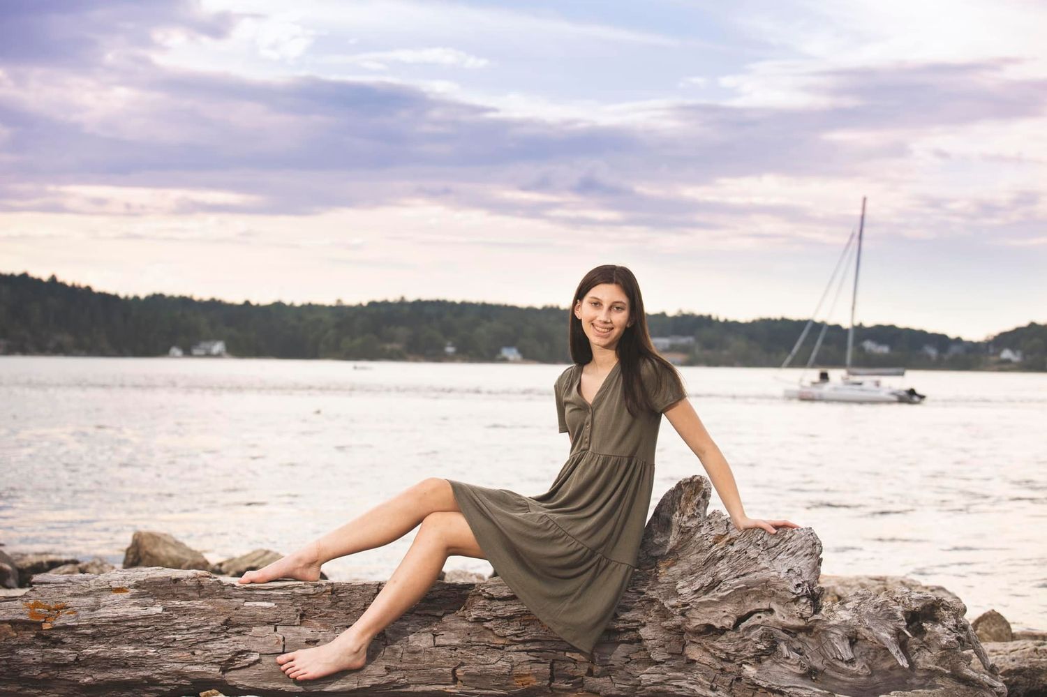 High school senior sitting on the rocks at Fort Popham
