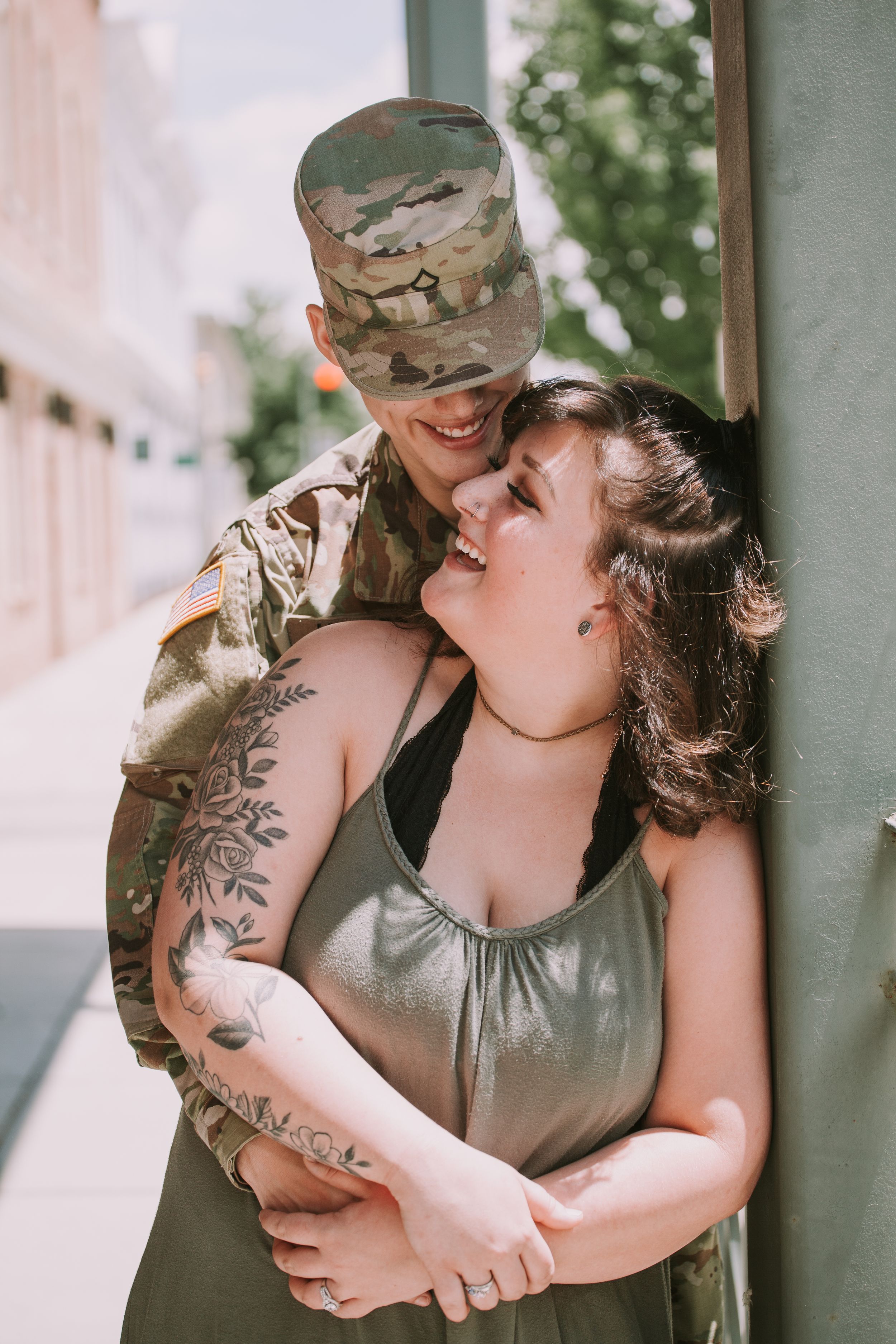 A couple shares intimate laughter while embracing on an outdoor porch.