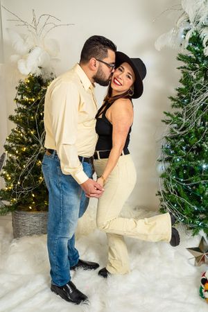 Romantic holiday photo session with Christmas trees and twinkling lights.