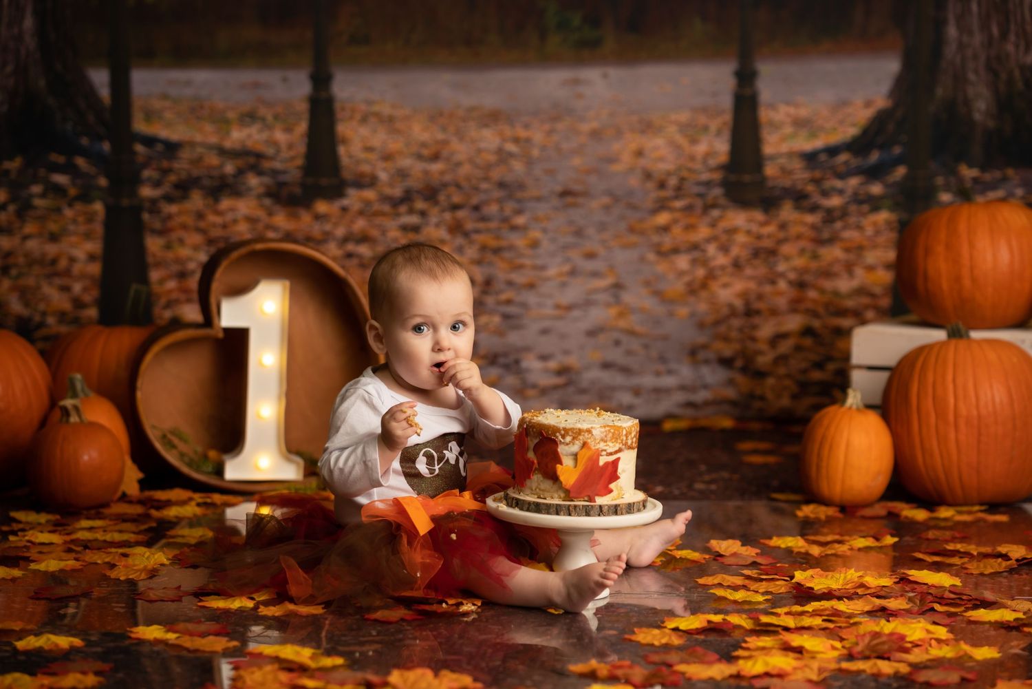 Toddler enjoying a 1st birthday cake smash session in a Bothell studio. Fun, authentic birthday photography by Filling the Frame Photography