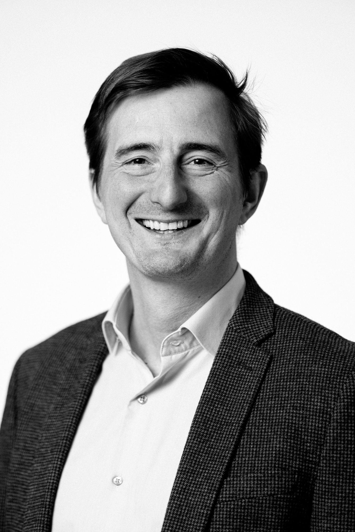 Professional headshot of person in business attire against white background.