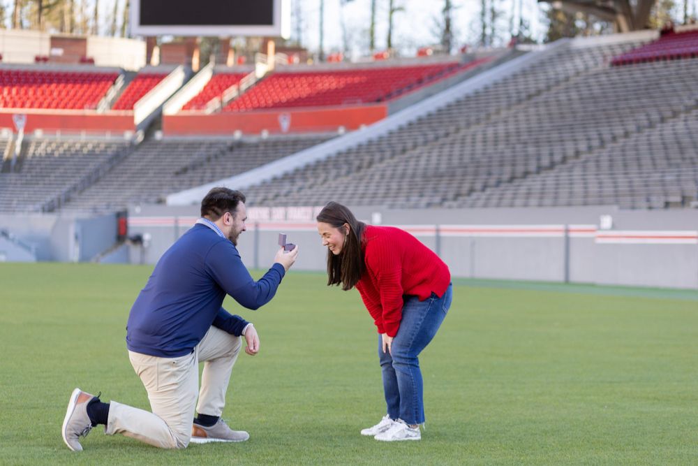 A couple has a proposal at NC State University on the football field.