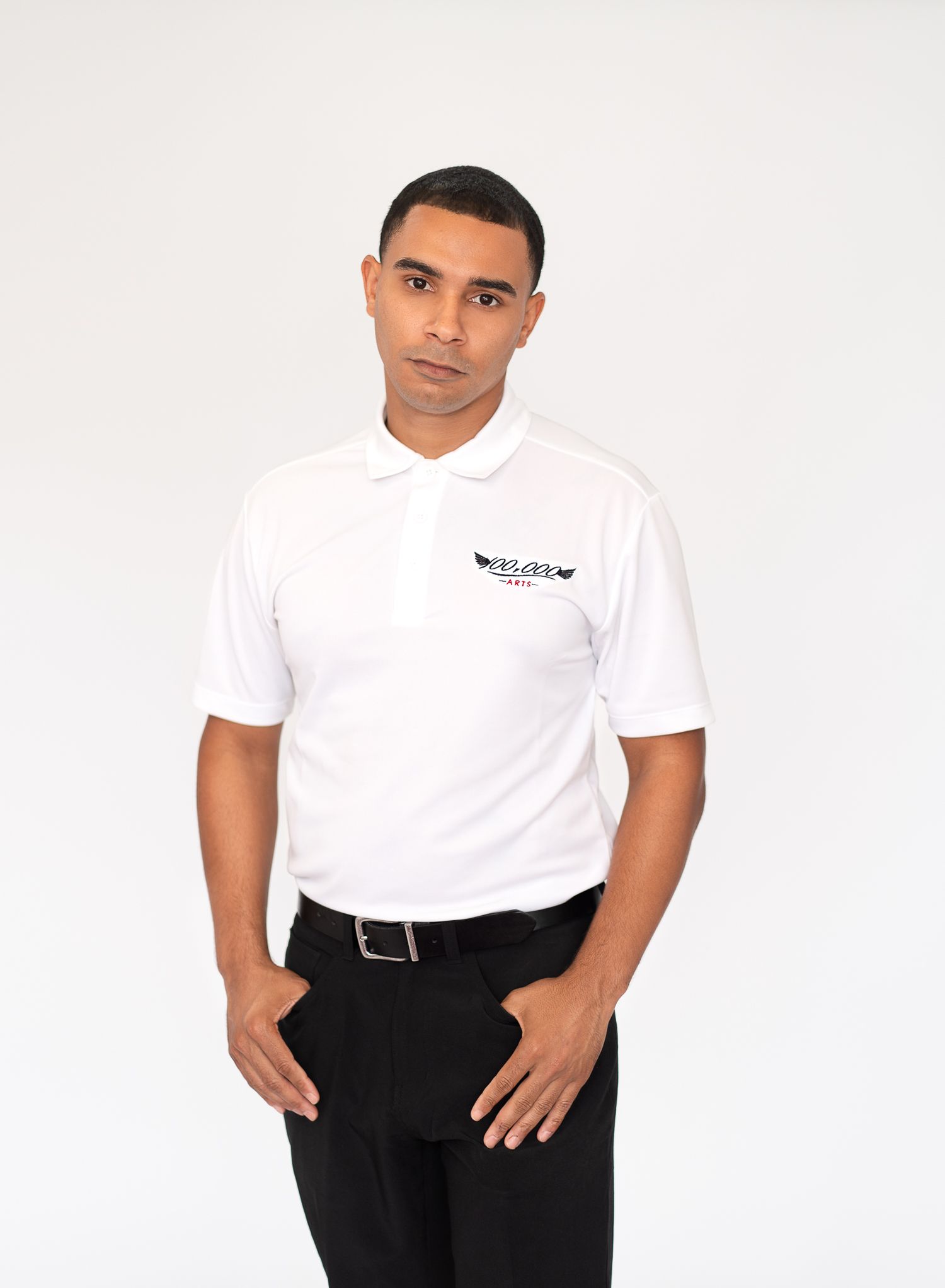 Professional headshot of person in white polo shirt with company logo against white background.