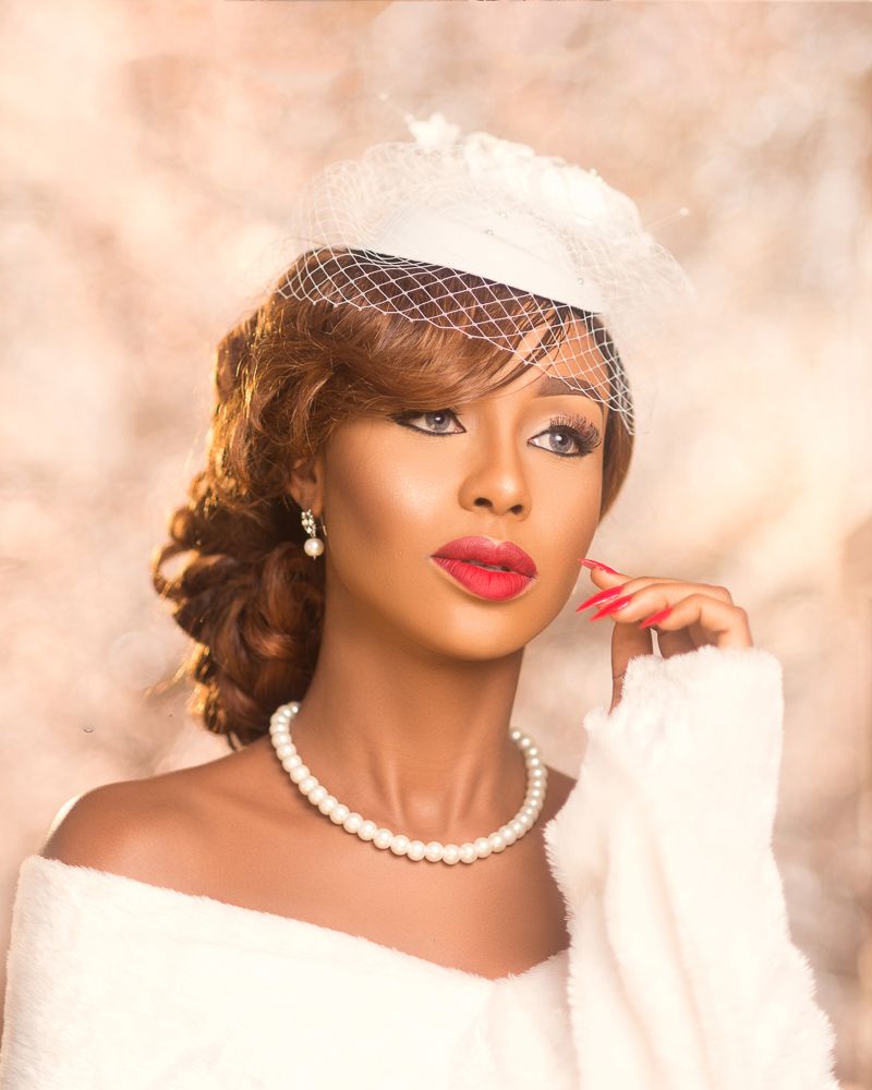 vanity fair inspired female bridal portrait with fascinator , pearl s and red lips