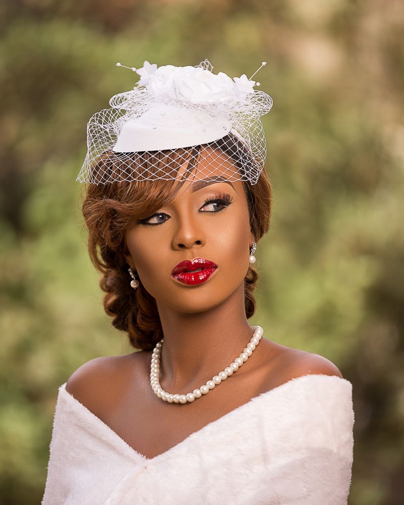 outdoor female bridal portrait with fascinator, pearls and red lips
