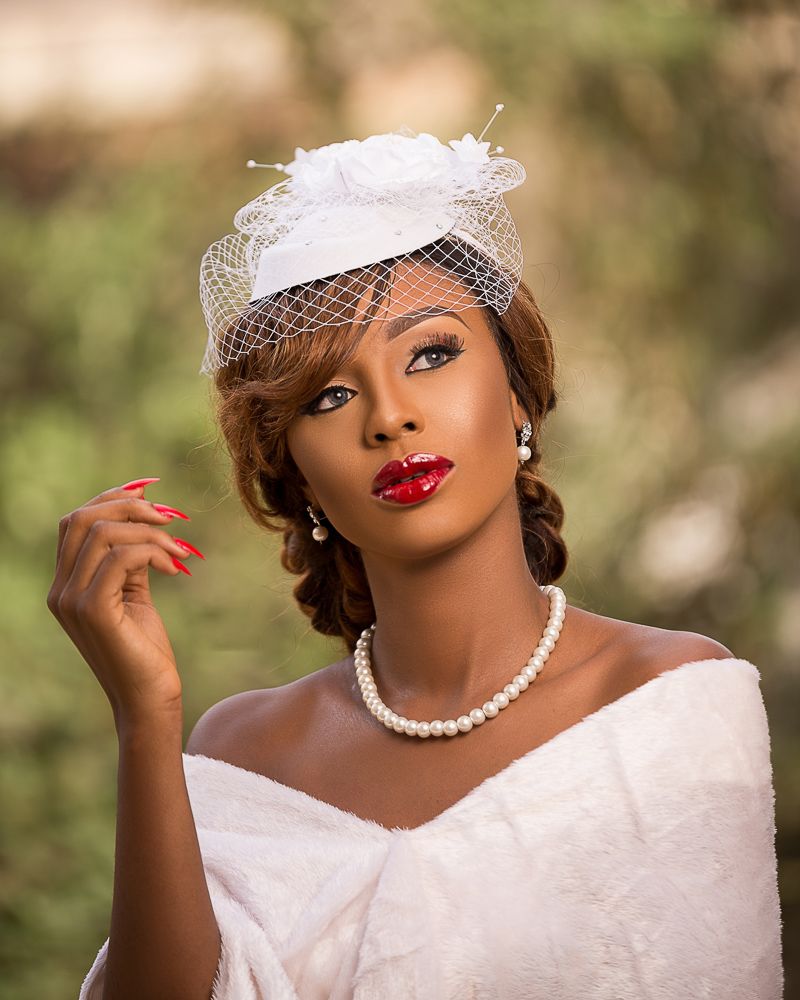 outdoor female bridal portrait with fascinator, pearls and red lips | Nigerian photographer