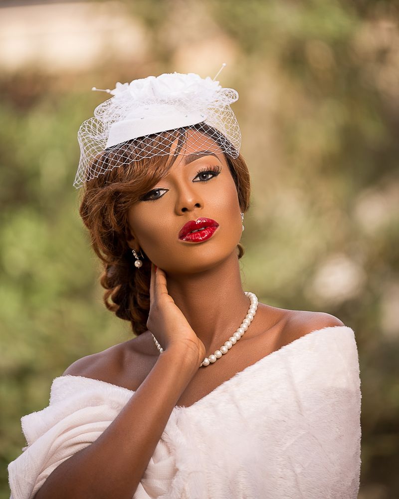outdoor female bridal portrait with fascinator, pearls and red lips | Nigerian photographer