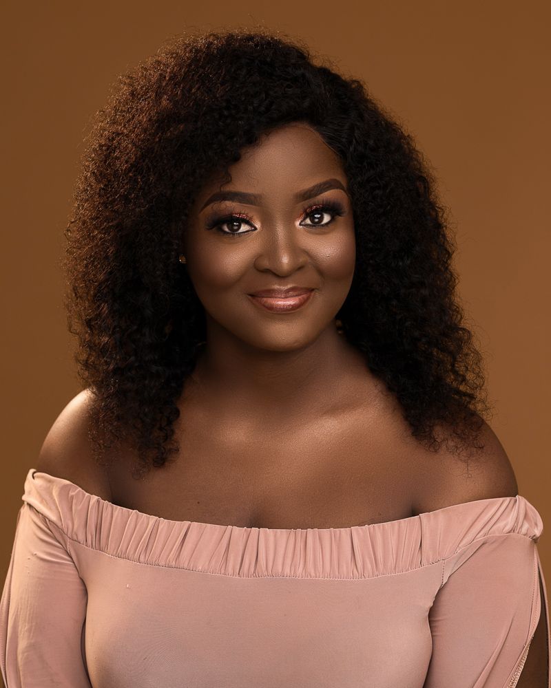 african plus size female portrait with curls and nude dress
