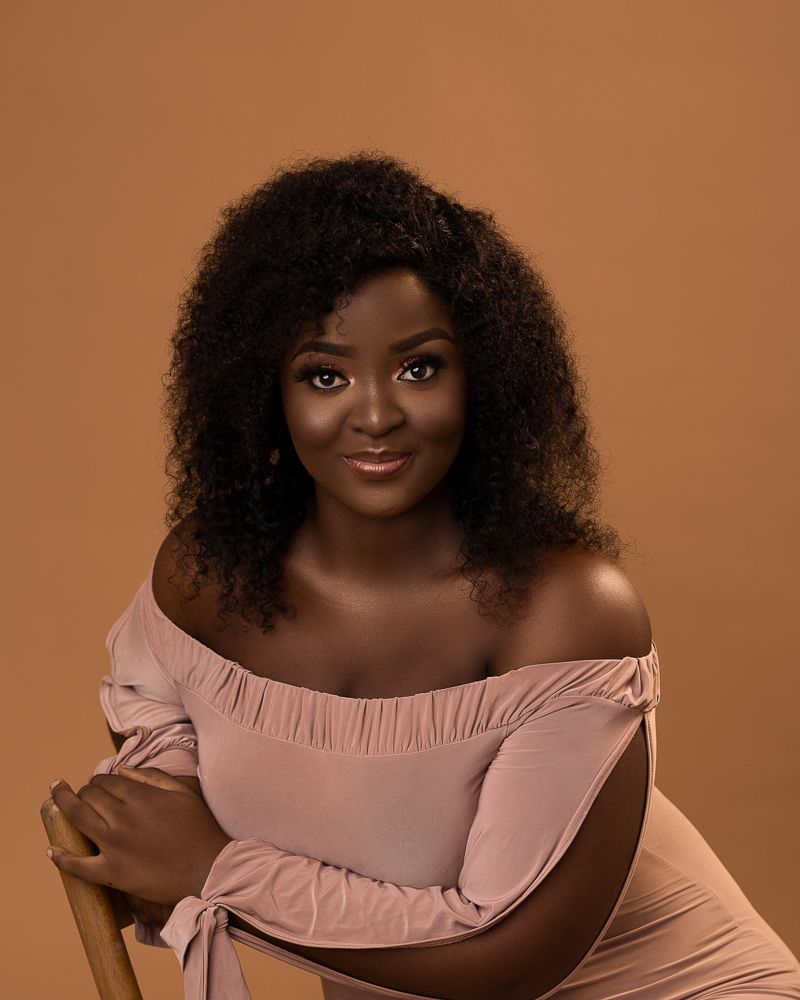 african plus size female portrait with curls and nude dress