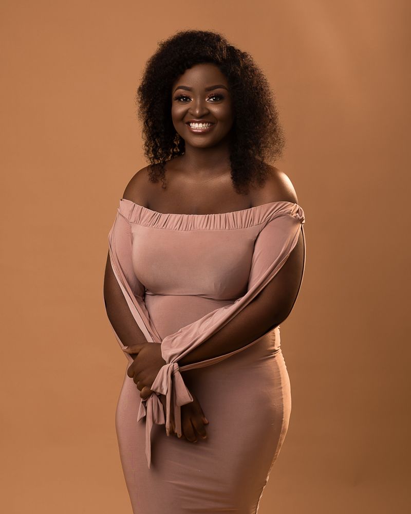 african plus size female portrait with curls and nude dress