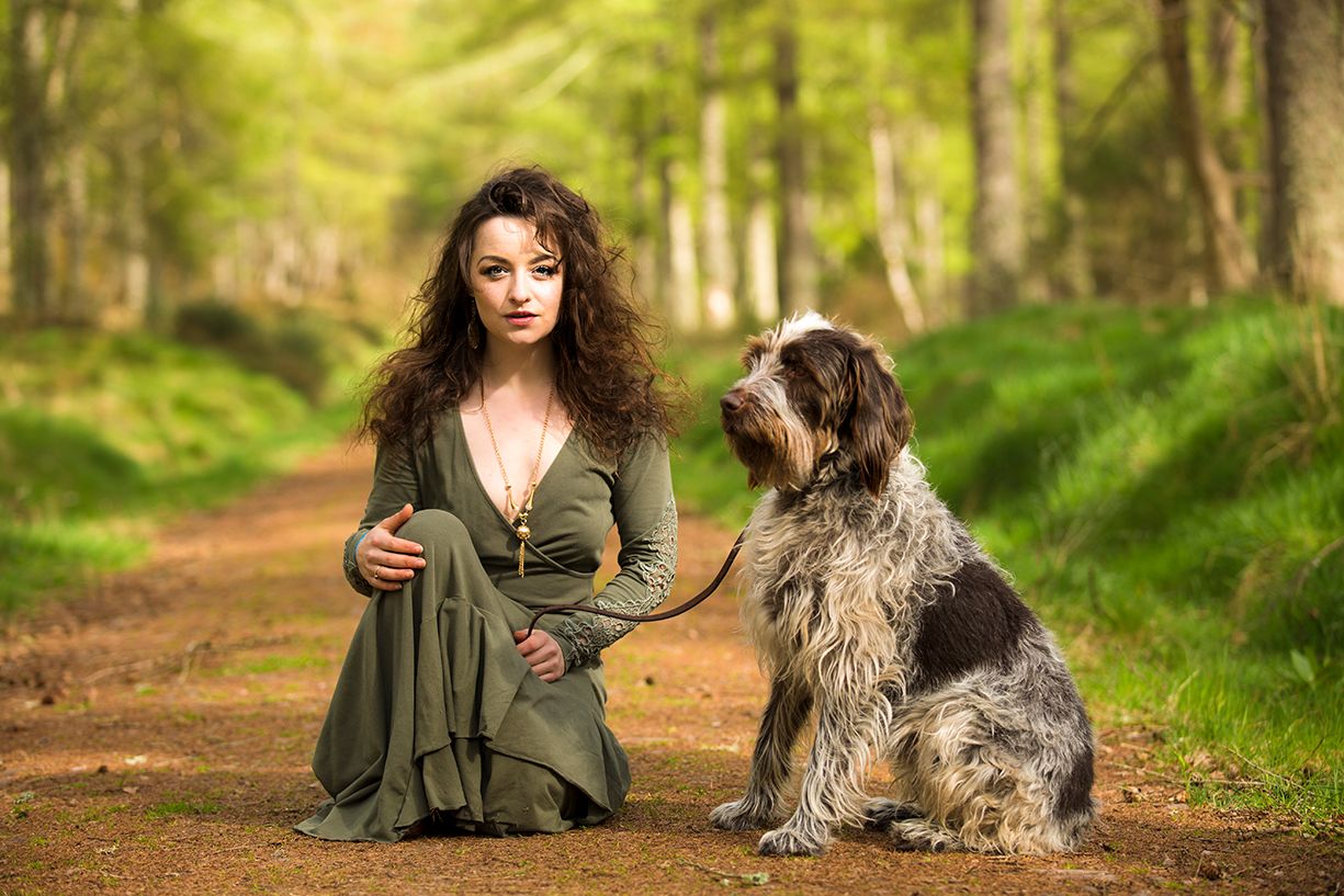 Gorgeous women posing with her beloved dog in the woods