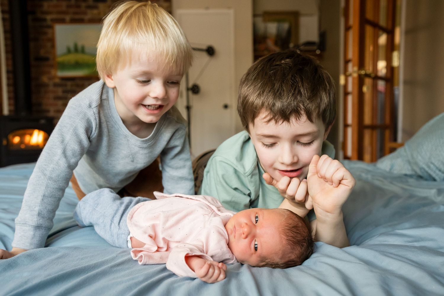 two brothers admiring baby sister