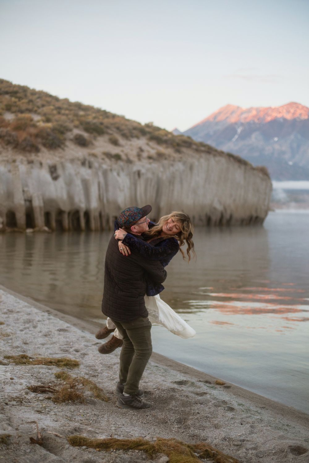 Couple Hugging on the shore of Crowley lake at sunrise