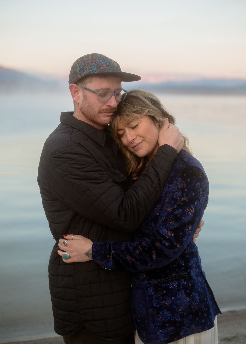 dreamy photograph of couple embracing at sunrise with Mammoth mountains backdrop at sunrise