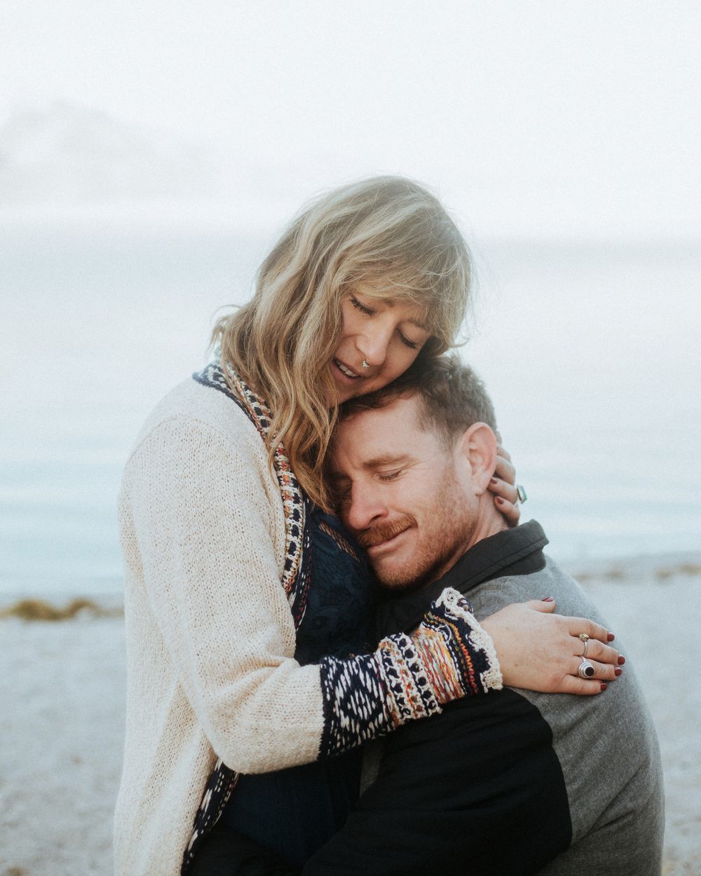 dreamy couples portrait of man and woman hugging at lake