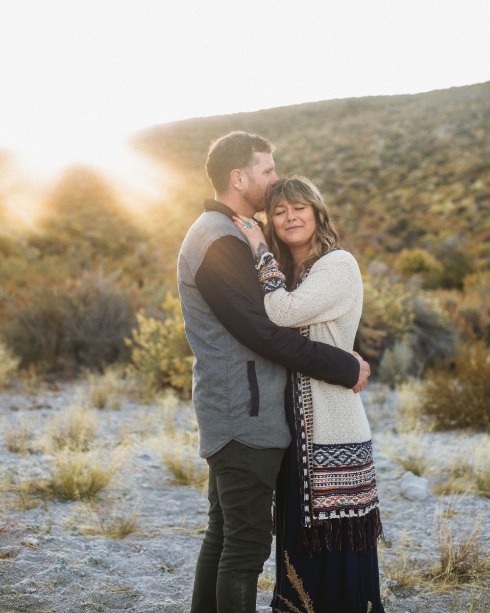 golden hour couples photo of man kissing woman's head