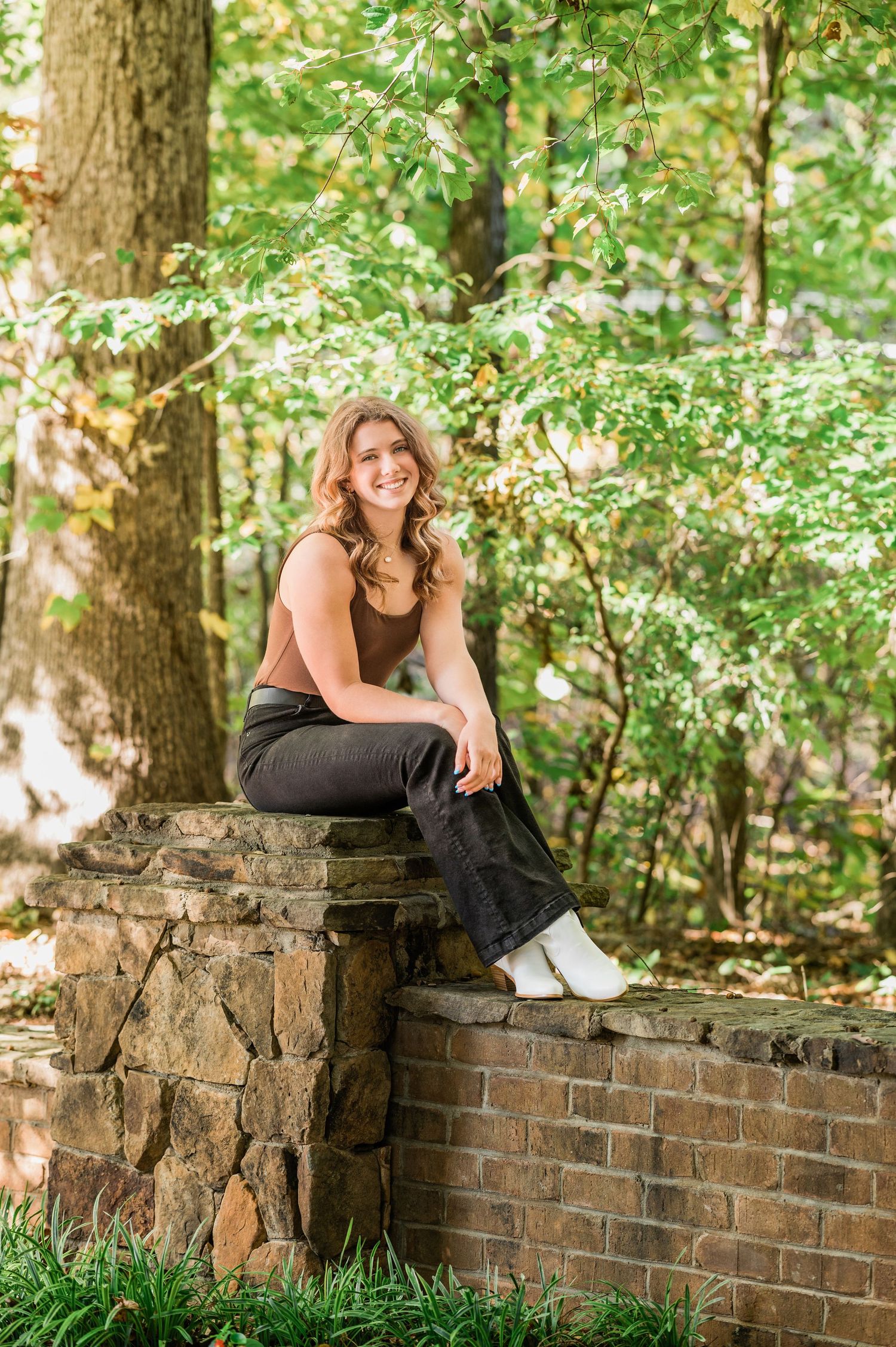 Stone and brick wall provides rustic backdrop for outdoor photography session.