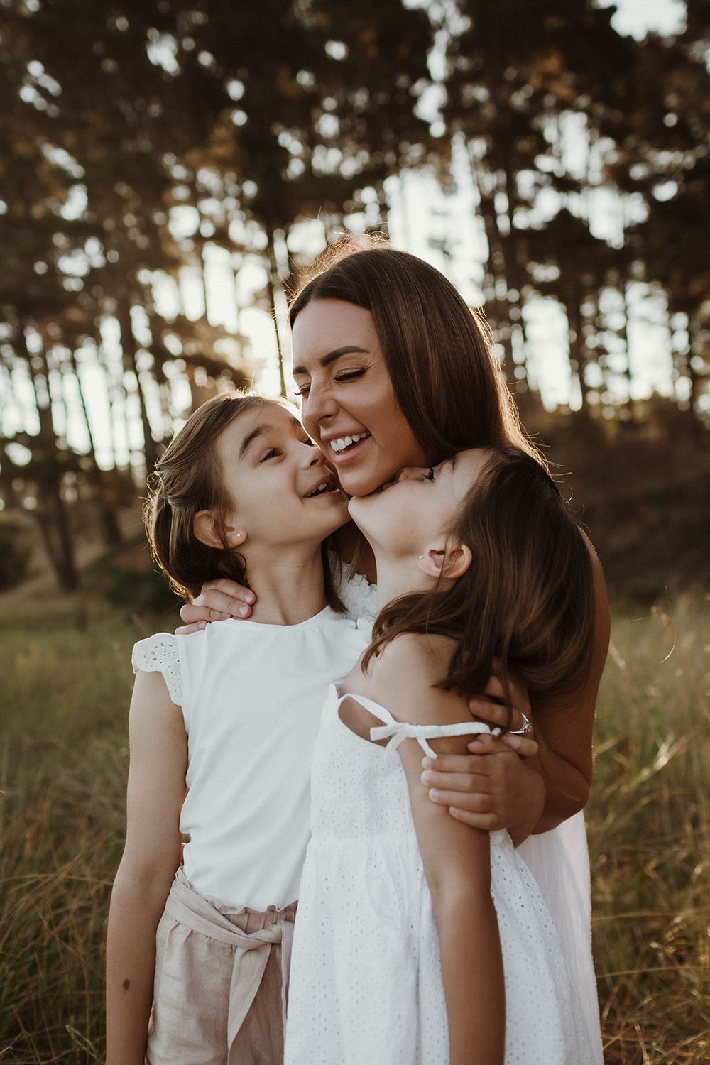 A joyful moment of affection shared in a wooded setting at golden hour.