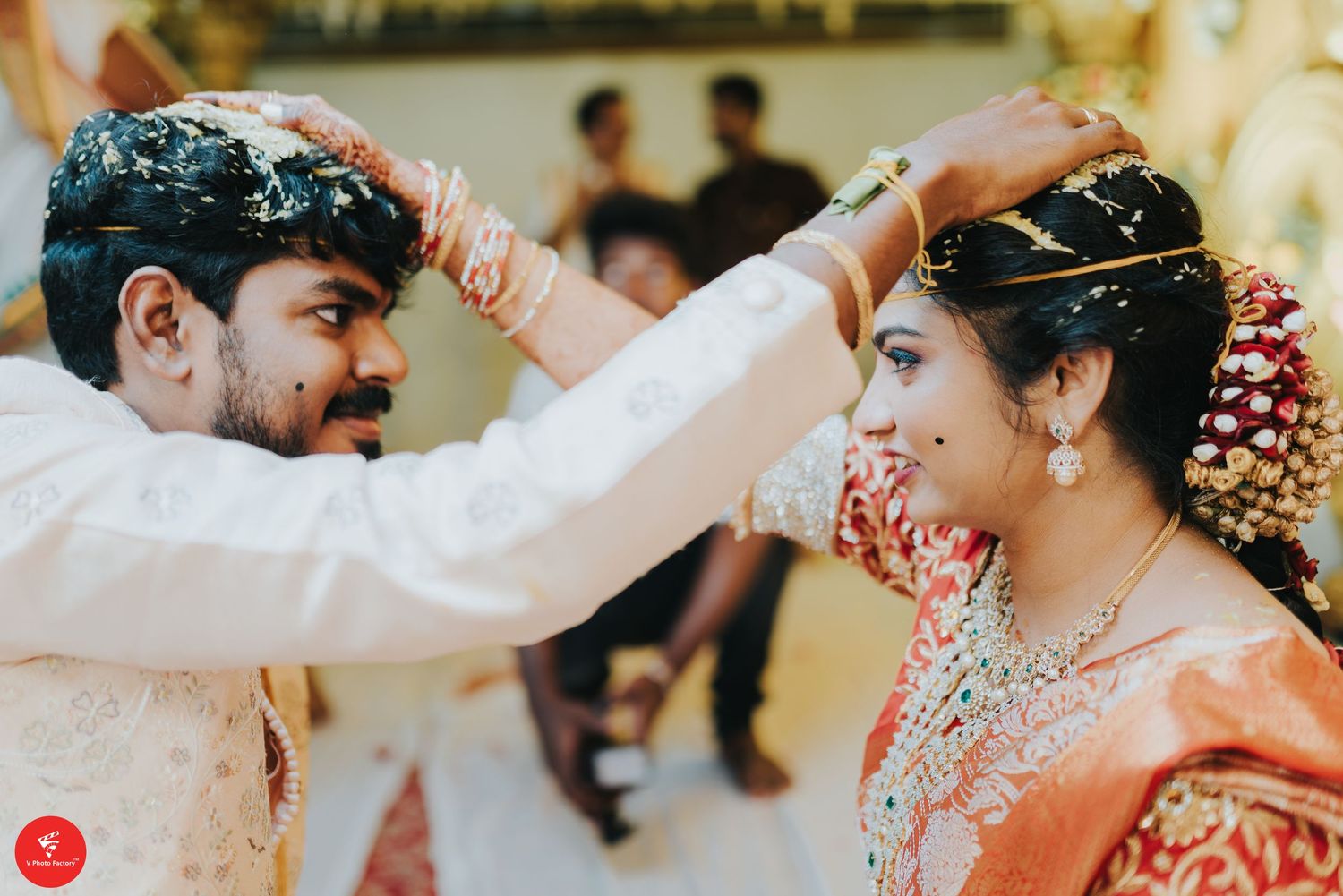 Traditional Indian ceremony features an intimate moment as turmeric is applied during pre-wedding rituals.
