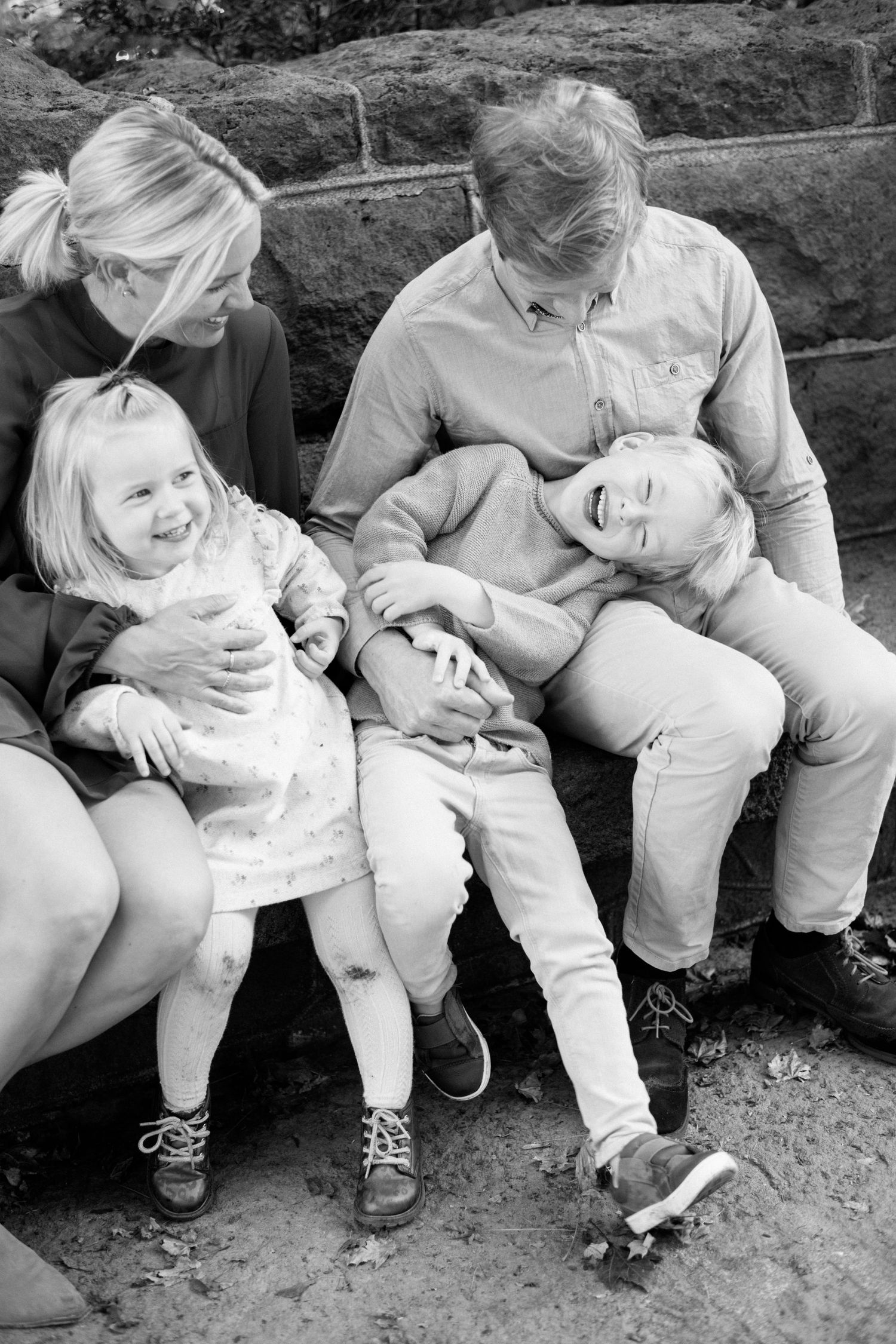 A candid black and white family portrait showing genuine laughter and joy.