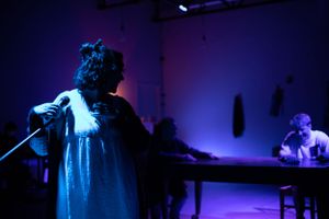 A performer sings on stage in dramatic blue lighting during a theatrical production. From Mary's Wondrous Body in 2022, Elision Playhouse.
